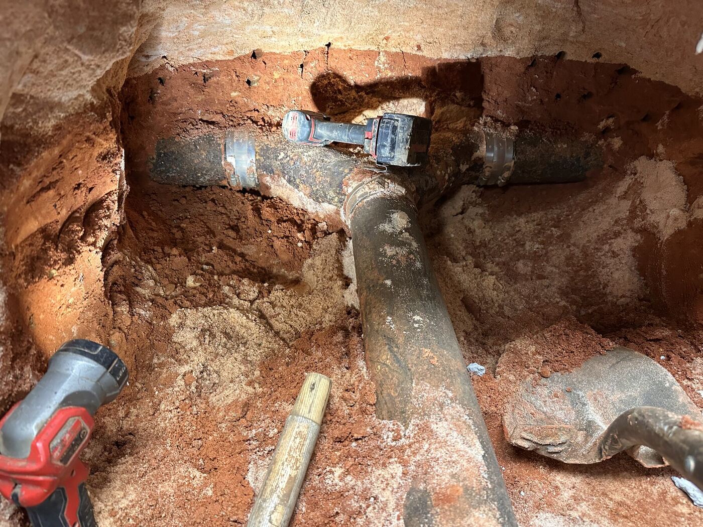 Existing buried drain piping exposed below the concrete slab